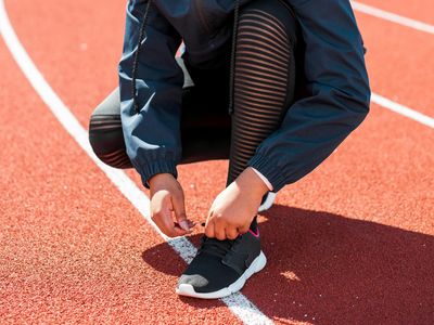 Close up of person tying laces on athletic running shoes